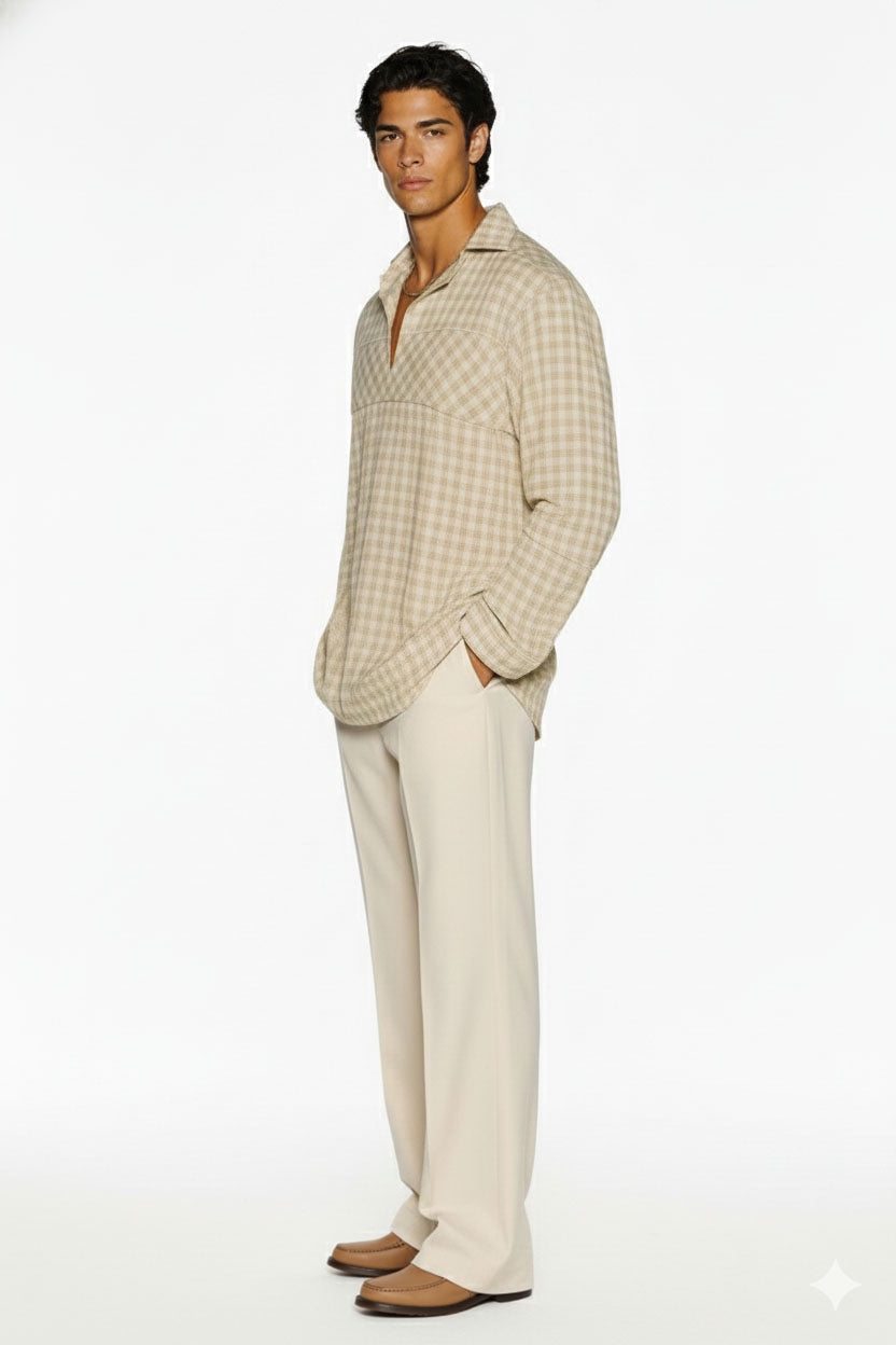 Man wearing a beige checkered casual shirt with relaxed fit and white trousers.